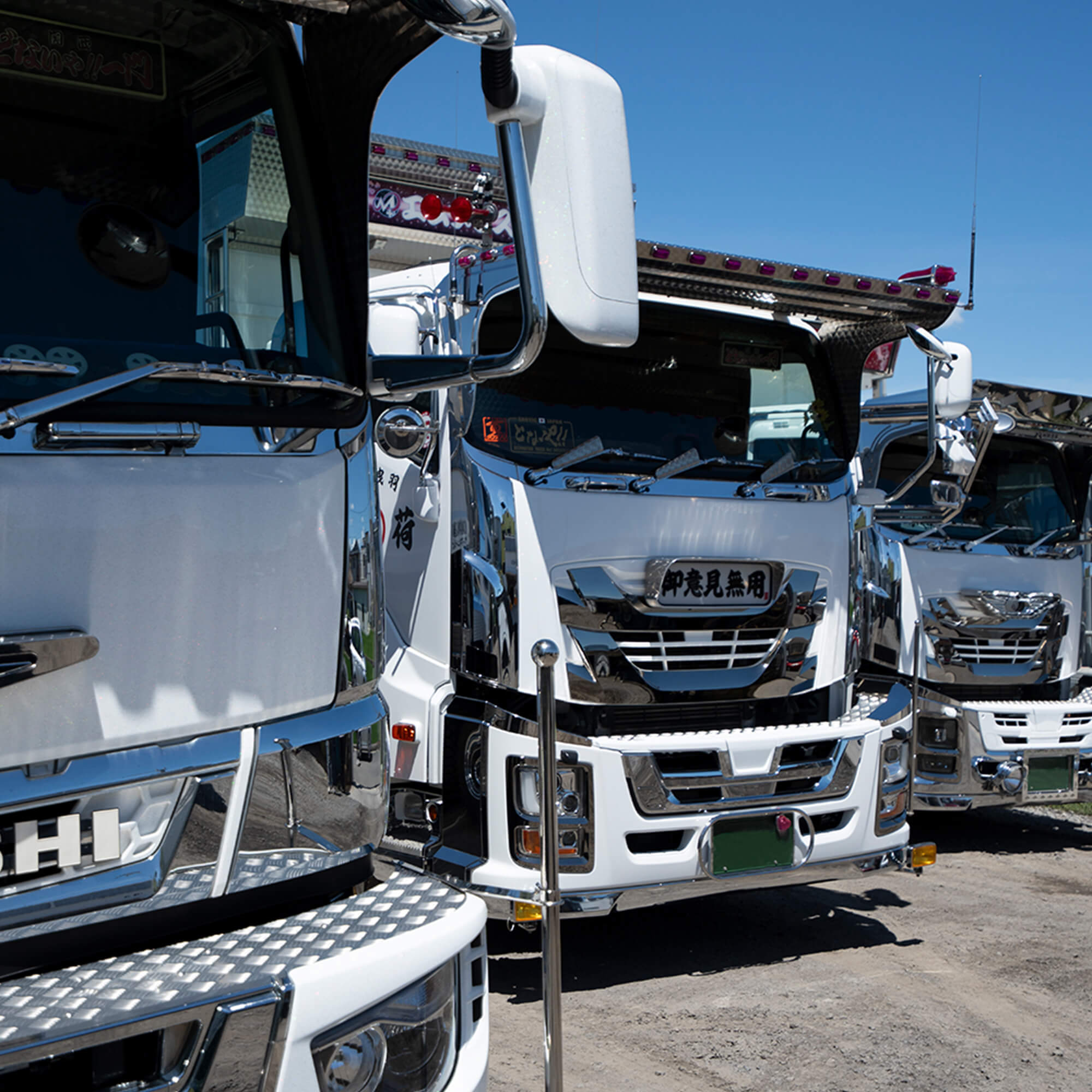 整列するエムプラスの白いダンプカー