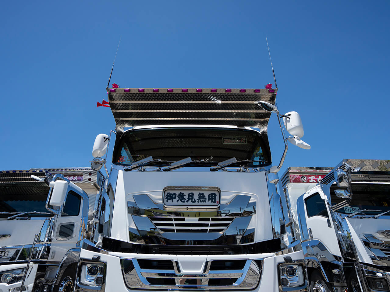「御意見無用」と掲げたフロントパネルが印象的な大型ダンプトラックが並んでいる
